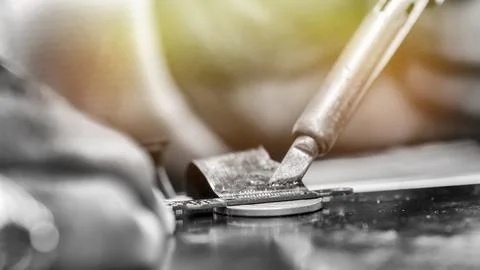 Technician restoring computer connector using special paste in electronics .. Foto stock