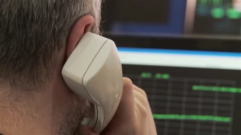 Technician with Retro Handset Analyzing Data on Computer Screen Stock Footage 83127214