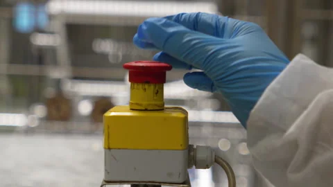 Technician rotating and resetting emergency stop button, slow motion Stock Footage 346180482