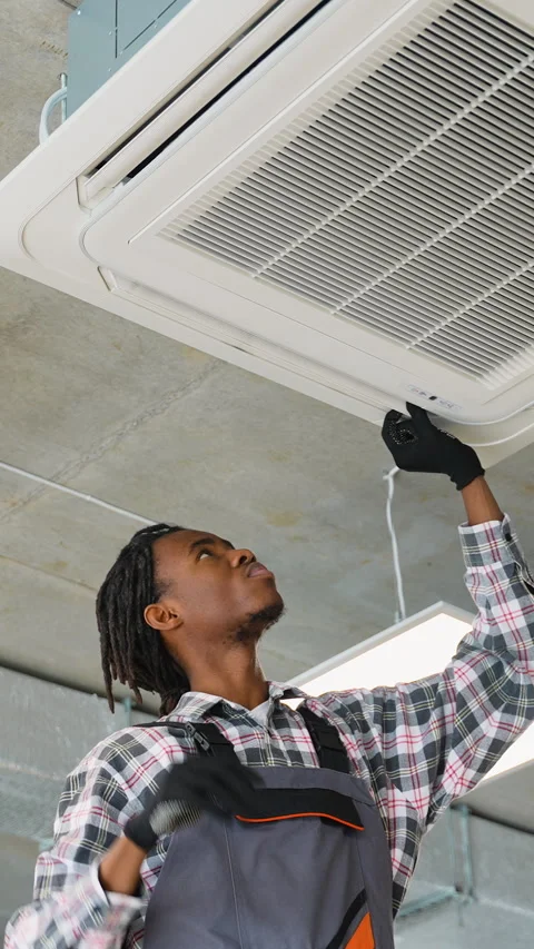 Technician secures ceiling air conditioner cover Video stock 309485794