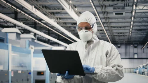 Technician in semiconductor production plant facility using laptop software Stock Footage 333392254