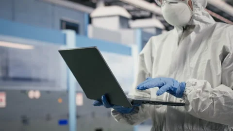 Technician in semiconductor production plant facility using laptop software 库存影片 333394731