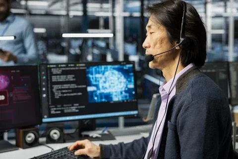 Technician in server farm doing tech support, fixing hacking warnings Stock Photos