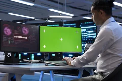 Technician in server farm using isolated screen PC to stop hacker 写真素材