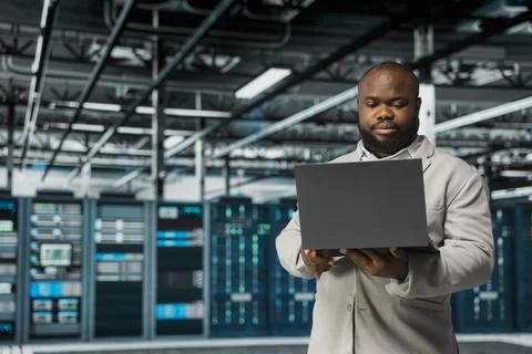 Technician in server hub managing infrastructure systems, checking recovery plan Stock Photos