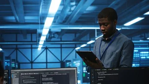 Technician in server hub using tablet to find hardware misconfigurations 스톡 사진