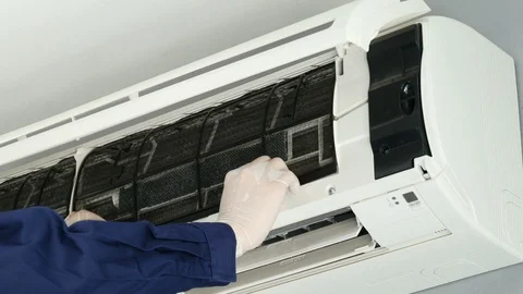 Technician service placing back clean filter into air conditioner Stock Footage 124592108