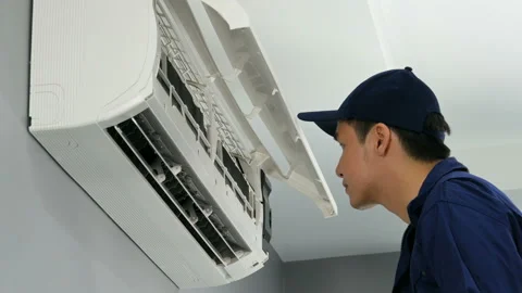 Technician service placing back clean filter into air conditioner Stock Footage 134643542