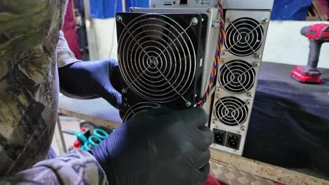 Technician servicing cooling fan on cryptocurrency mining hardware Stock Footage 321813879