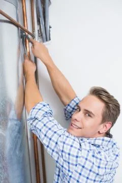Technician servicing an hot water heater' pipes Stock Photos