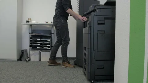 Technician sets up a multi-function copier device. Stock Footage 170739357