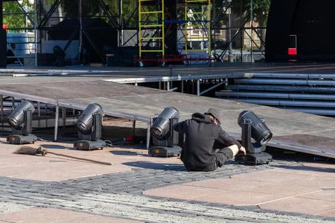 Technician setting up professional stage lighting equipment Stock Photos