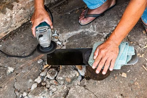 A technician is sharpening a knife for use in construction work. Stock Photos