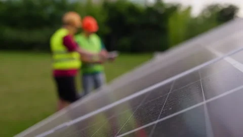 Technician shows client how to manage solar panel operation via digital tablet Stock Footage 327912152