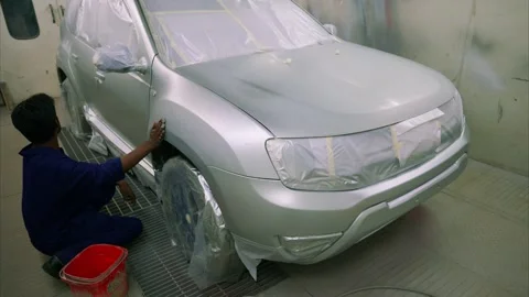 Technician smooths vehicle surface with abrasive sheet Stock Footage 304498275