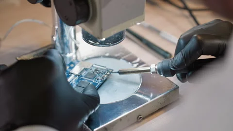 Technician Soldering Components on Circuit Board Under Microscope Video stock 282300956