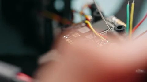 Technician soldering components onto circuit board of disassembled fpv drone Stock Footage 346727958