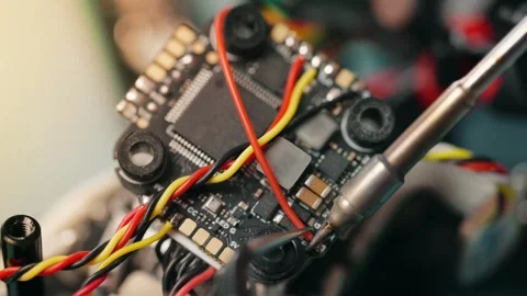 Technician soldering components onto circuit board of disassembled fpv drone Stock Footage 346727961