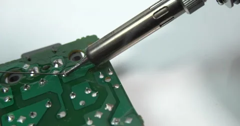Technician soldering leg of a component on circuit board. Electronics repair Video stock 168760674