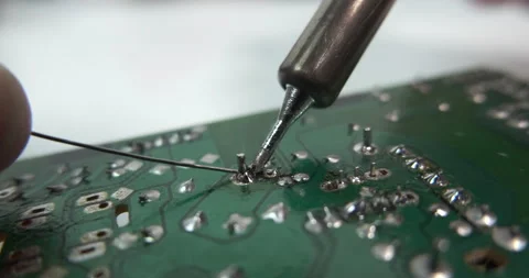 Technician soldering leg of a component on circuit board. Electronics repair. Stock Footage 168760691