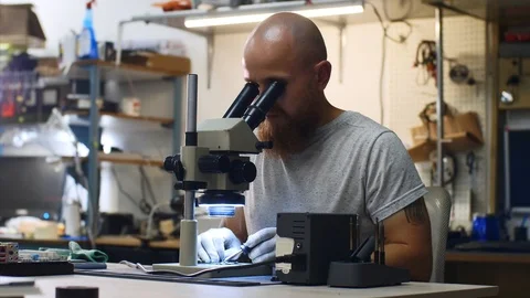 Technician is soldering microchip looking through microscope in service center. Stock Footage 114609184