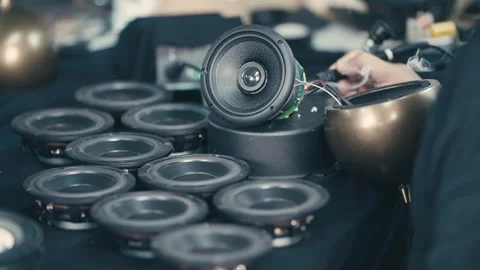 Technician soldering speaker components on a workbench inside electronics Stock Footage 320667452