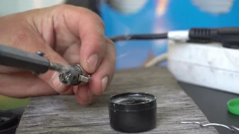 Technician solders cable to a XLR plug with a soldering iron. Close-up Stock Footage 135538192