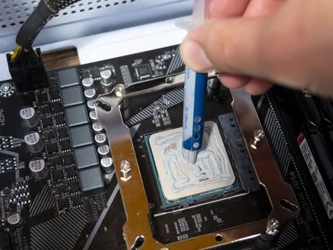 Technician spreading thermal compound on computer processor, optimizing coo.. Stock Photos