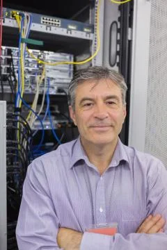Technician standing in front of servers Stock Photos