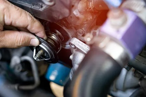 Technician take of Car thermostat in engine room and check water heating of.. Foto stock