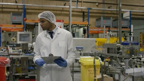 Technician talking to production workers at work in cosmetic factory Stock Footage 107951355