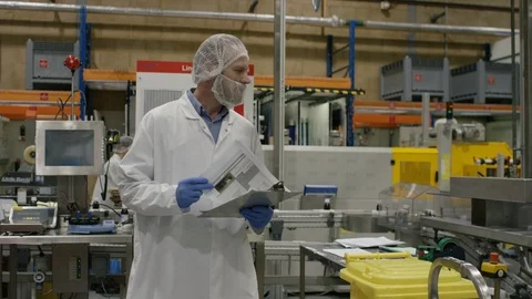 Technician talking to production workers at work in cosmetic factory Stock Footage 107952269