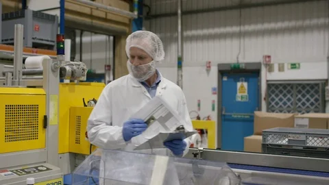 Technician talking to production workers working in cosmetic factory Stock Footage 107955902