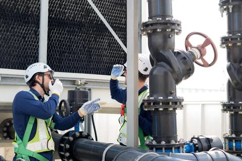 Technician team checking pipe valve, industrial maintenance service monitor.. Stock Photos