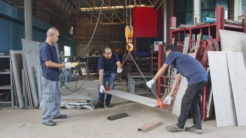 Technician team using hoist crane for lifting metal sheet in workshop factory Stock Footage 204055325