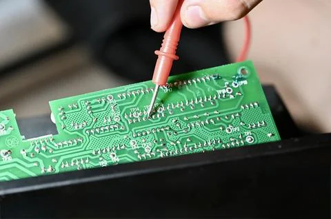 Technician Testing Circuit Board with Multimeter Probe Close-up Stock Photos