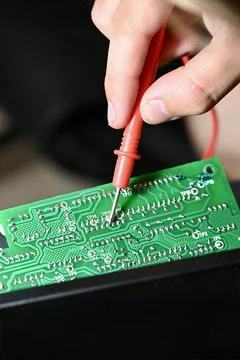 Technician Testing Circuit Board with Multimeter Probe Close-up Stock Photos