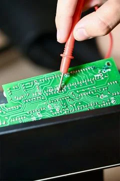 Technician Testing Circuit Board with Multimeter Probe Close-up Stock Photos