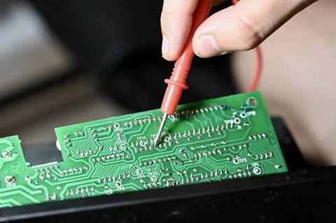Technician Testing Circuit Board with Multimeter Probe Close-up Stock Photos