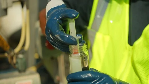 Technician testing fuel quality with syringe in field Stock Footage 123729781