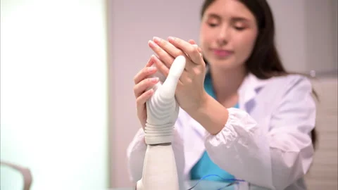 Technician testing robotic bionic arm at prosthetic manufacturing Stock Footage 241525816