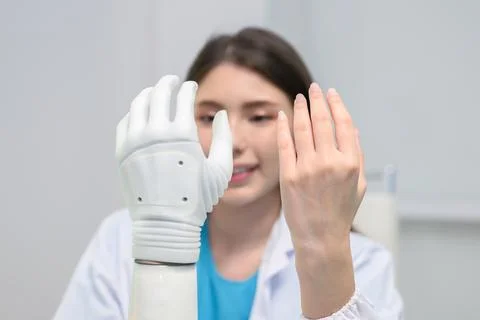 Technician testing robotic bionic arm at prosthetic manufacturing Stock Photos