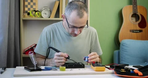 Technician tests computer hard drive with multimeter at organized workstation Stock Footage 346040075