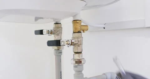 Technician tests pressure relief valve on heater with glass tube Stock Footage 322009141