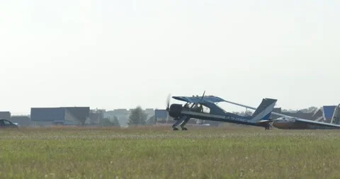 A technician ties a glider to a small plane with a cable before taking off. Video stock 160785670