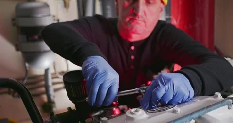 Technician Tightens Engine Bolts in Mechanical Room Stockbeeldmateriaal 323738551
