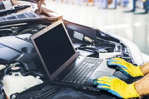 Technician tuning engine car with the computer laptop in repair garage,blank  Stock Photos