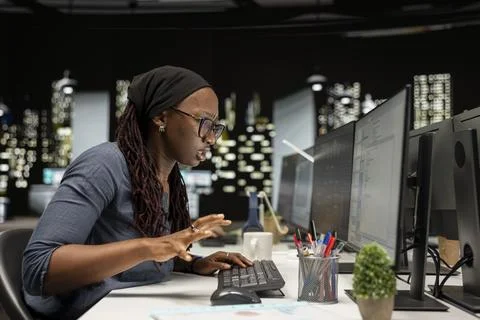 Technician typing on PC keyboard in startup office, optimizing code 스톡 사진
