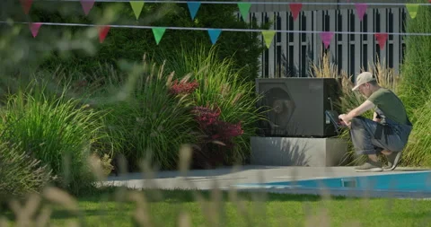 Technician in uniform with tablet checking a pool heat pump near water Stock Footage 308940211