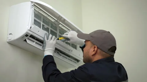 Technician in uniform use screwdrivers to fix the air conditioner. Air condition Stock Footage 234256164